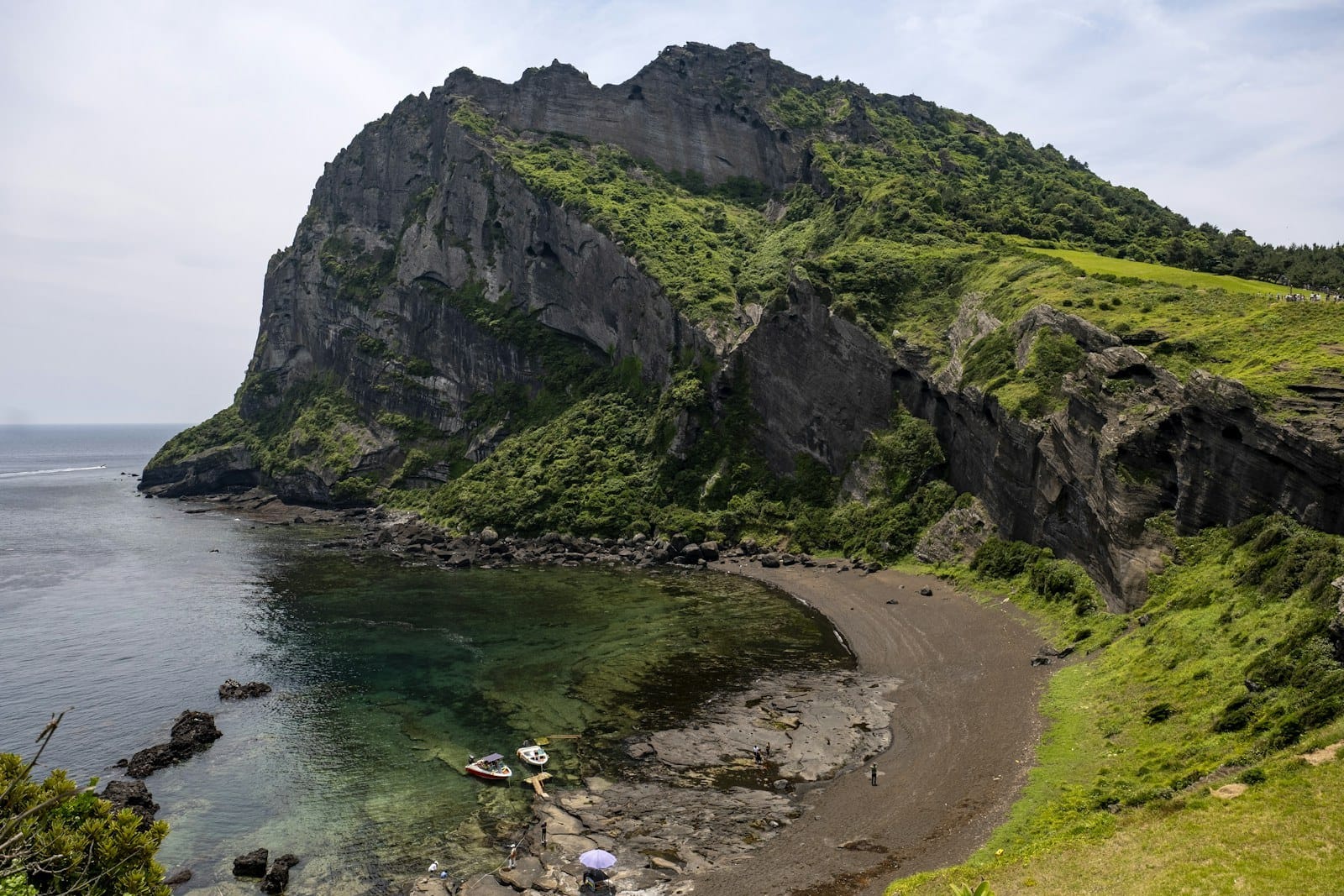 Green volcanic cliffs above a sheltered cove on Jeju Island