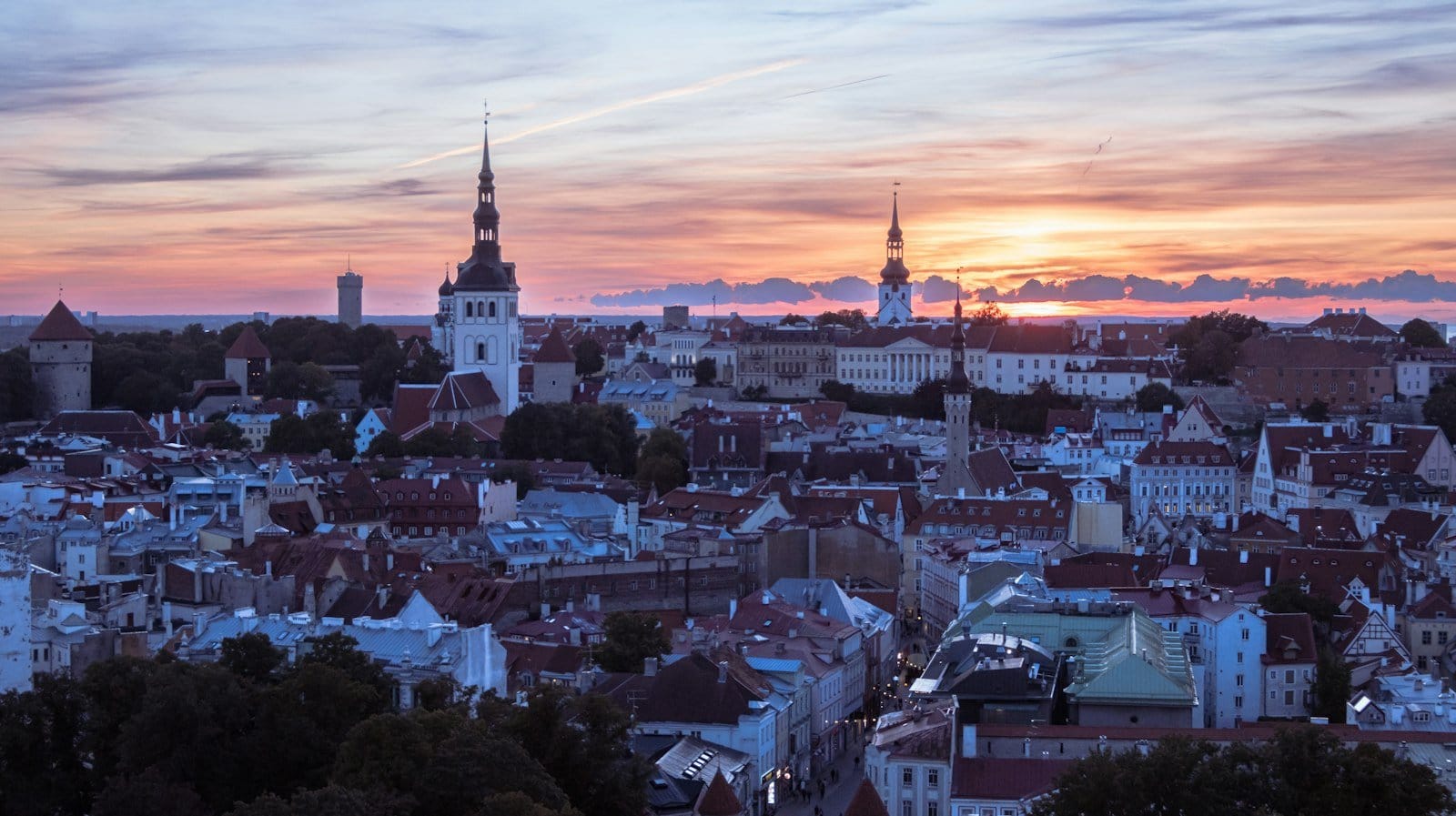 Tallinn old town rooftops at golden sunset, towers and church spires