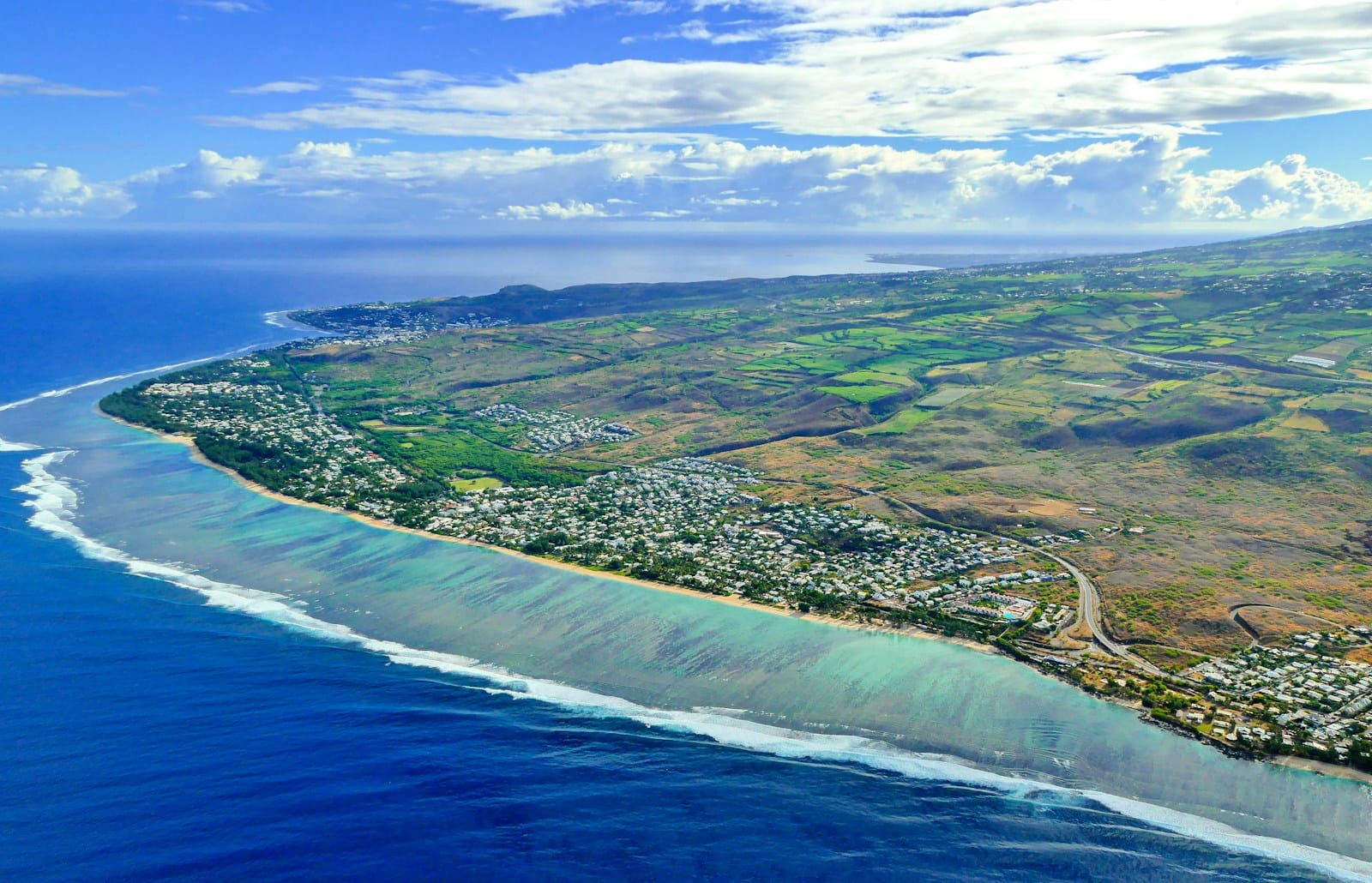 Aerial view of a turquoise reef-protected lagoon along the coast of Réunion Island